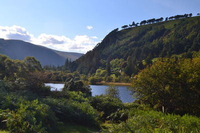 Scenic view of river and mountains against sky