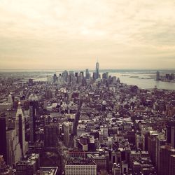 View of cityscape against cloudy sky