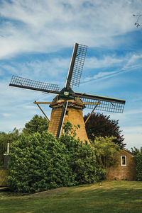 Traditional windmill on field against sky