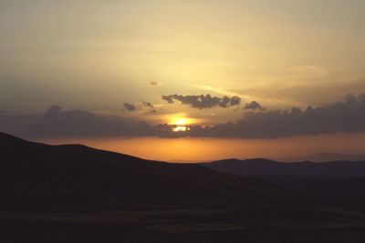 Scenic view of silhouette mountains against sky during sunset