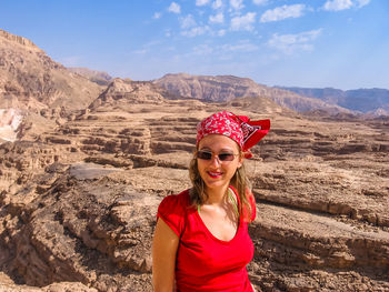 Portrait of woman wearing sunglasses while standing against mountains