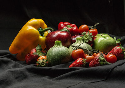 Close-up of fruits on tree against black background