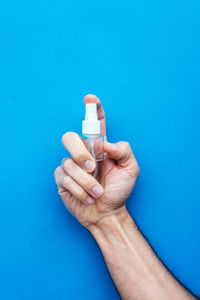 Close-up of man hand holding blue background