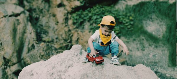 Full length of man with toy on rock