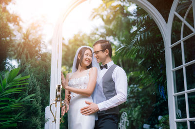 Loving wedding couple standing at backyard