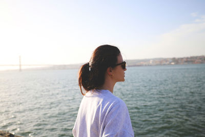 Side view of man looking at sea against sky