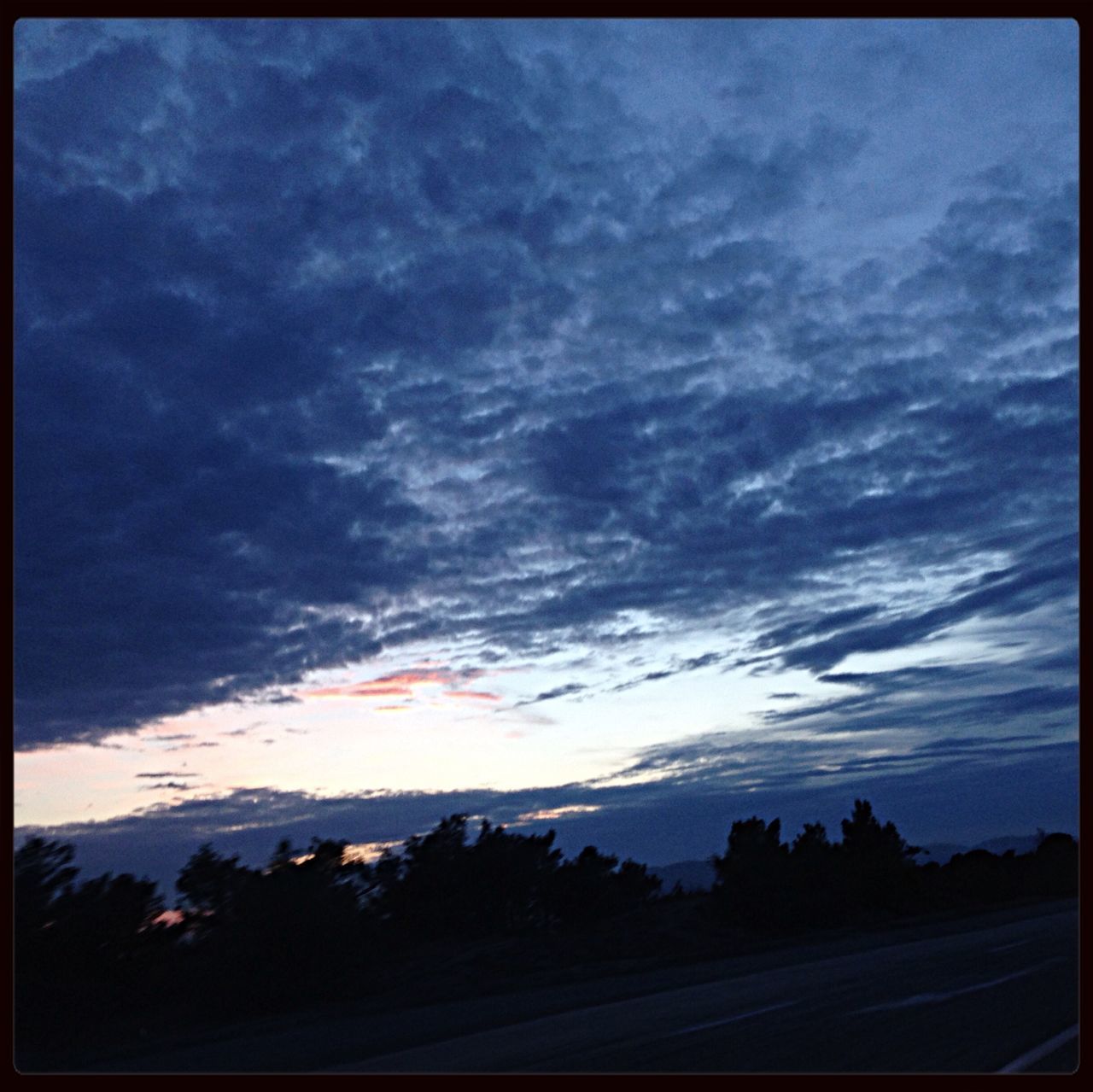 sky, transfer print, cloud - sky, transportation, auto post production filter, cloudy, car, silhouette, road, cloud, mode of transport, sunset, land vehicle, scenics, dusk, beauty in nature, nature, tree, weather, overcast