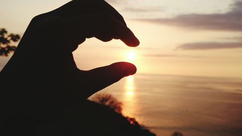 Cropped image of man looking at sunset