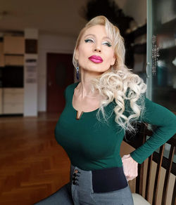 Portrait of woman standing against wall