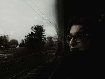 Man standing by railroad tracks against sky