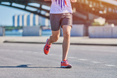 Running man. athletic man jogging in sportswear on city road. healthy lifestyle, street workout