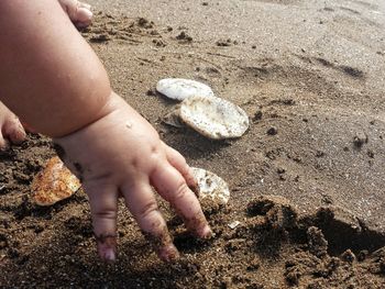 Close-up of hands on sand