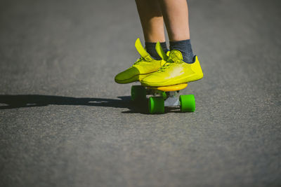 Low section of person skateboarding on road