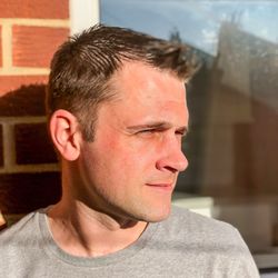 Close-up of mid adult man looking away against wall