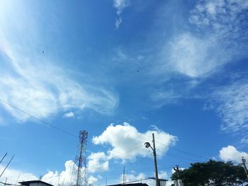 Low angle view of power lines against blue sky