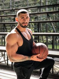 Portrait of muscular man holding basketball
