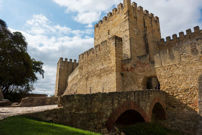 Low angle view of fort against cloudy sky