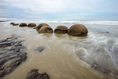 Rocks in sea against sky