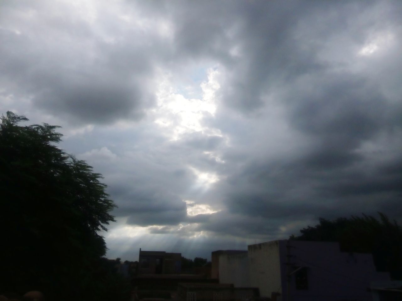 sky, cloud - sky, cloudy, building exterior, built structure, architecture, weather, overcast, storm cloud, low angle view, tree, silhouette, house, cloud, dusk, residential building, residential structure, nature, dramatic sky, city