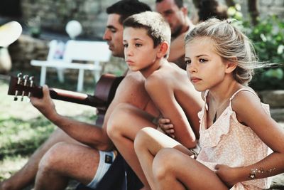 High angle view of shirtless boy sitting outdoors