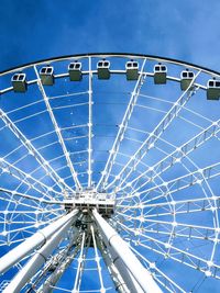 Low angle view of ferris wheel against blue sky