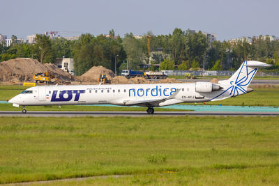 Side view of airplane on runway against sky