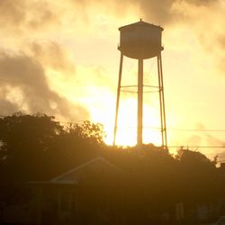 Low angle view of water tower against sky during sunset