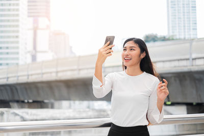 Young woman using mobile phone in city