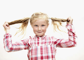 Portrait of girl holding pigtails, studio shot