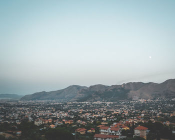 High angle view of houses in town against clear sky