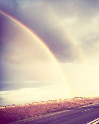 Scenic view of rainbow over landscape against sky