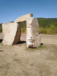 Stone wall on field against clear sky