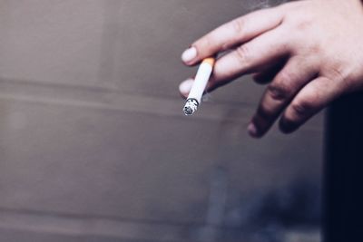 Cropped image of hand holding cigarette