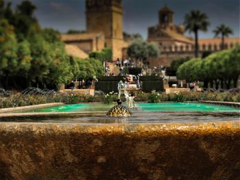 Fountain in city against sky