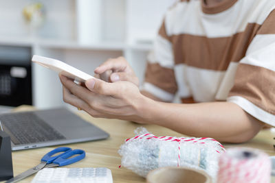 Midsection of man using mobile phone