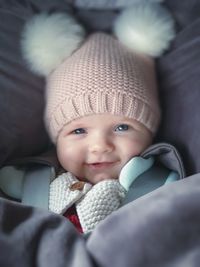 Portrait of cute smiling baby girl lying on bed 