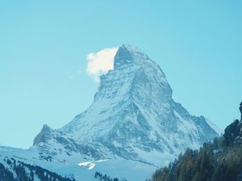 Low angle view of snow covered mountain against sky