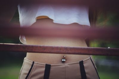 Midsection of woman standing behind railing