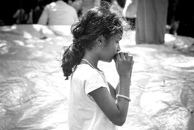 Side view of young woman drinking water