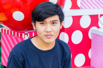 Portrait of young man sitting by gift boxes