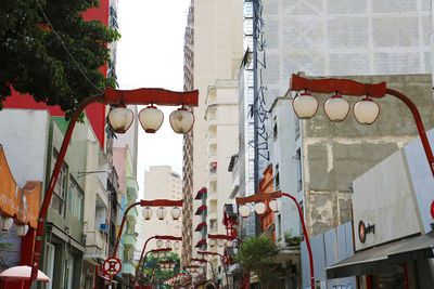 Low angle view of lanterns hanging by building