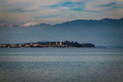 Scenic view of sea by buildings against sky