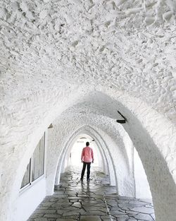 Full length rear view of woman walking in building