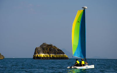 Sailboat in sea against clear sky