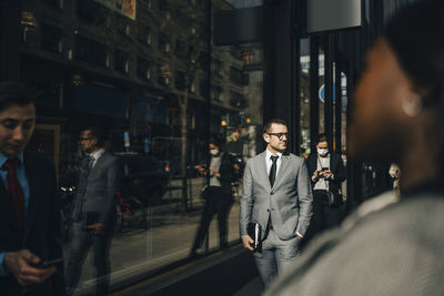 Businessman with hand in pocket on sunny day during pandemic