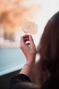 Close-up of woman holding dry leaf