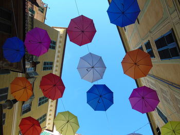 Low angle view of umbrellas hanging in city