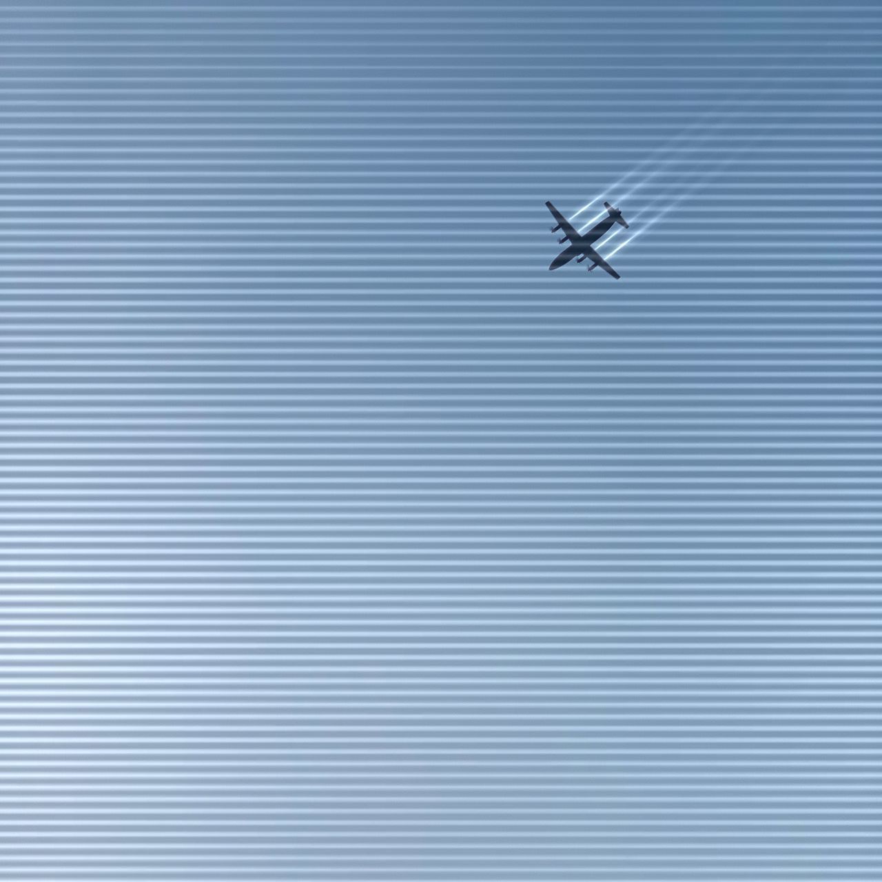 LOW ANGLE VIEW OF AIRPLANE FLYING IN BLUE SKY
