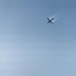 Low angle view of airplane against blue sky