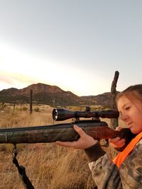 Young woman shooting with rifle